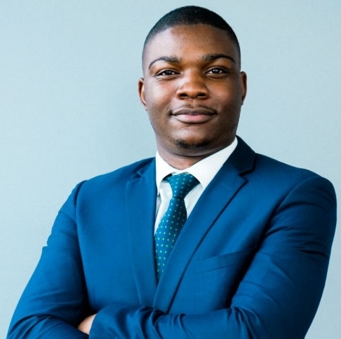 Portrait of confident businessman with arms crossed. Male entrepreneur is wearing blue suit. He is standing against gray background.